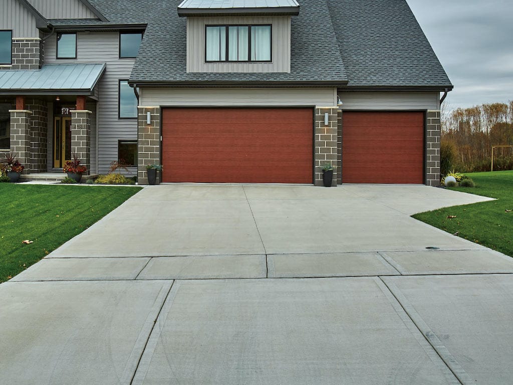 The wide concrete driveway complements the modern aesthetic of the home in Central Coast