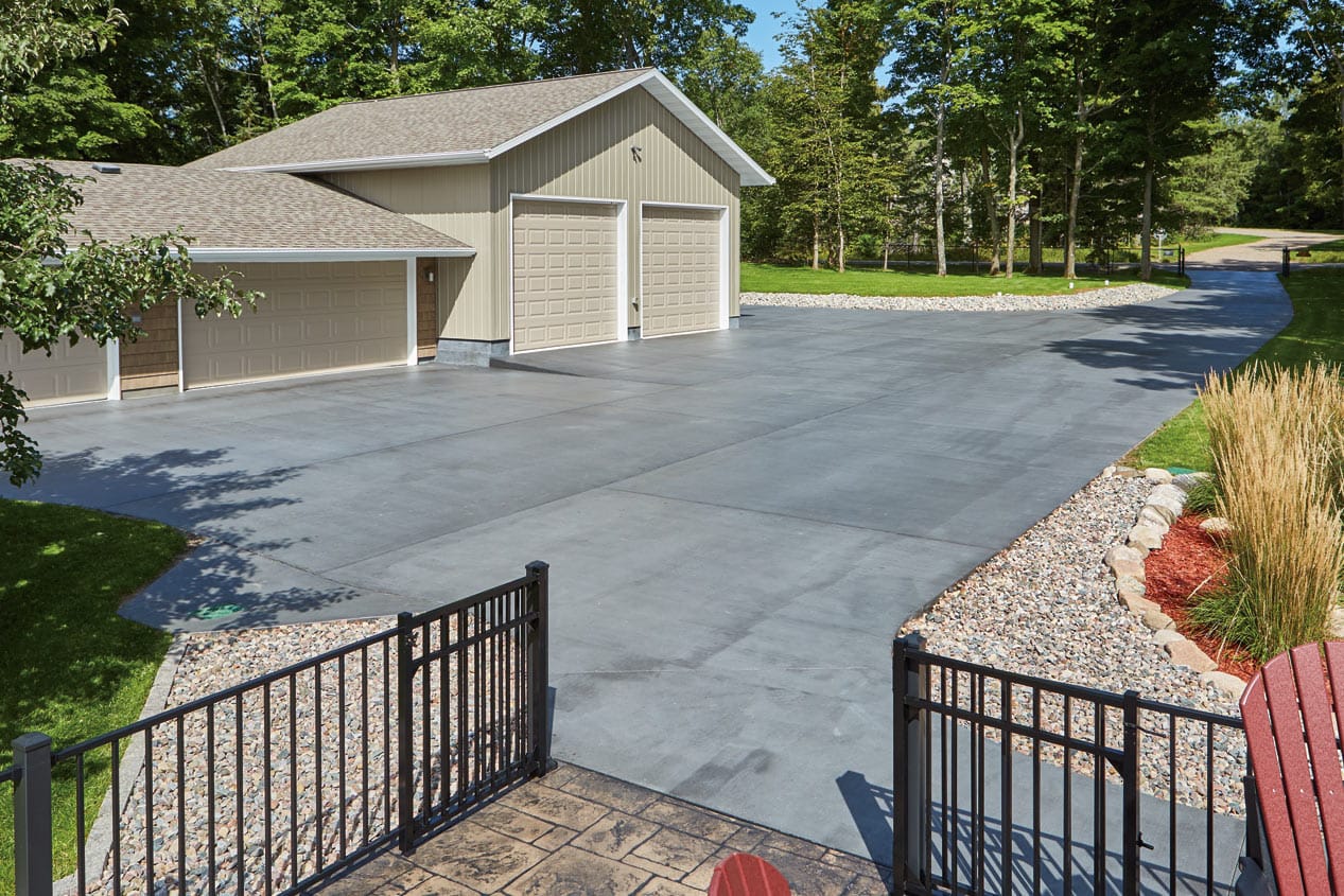 concrete driveway that connects the garages and main house
