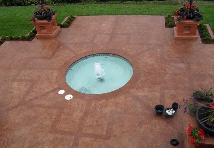 water fountain at the center of the outdoor patio with decorative concrete in a Central Coast home